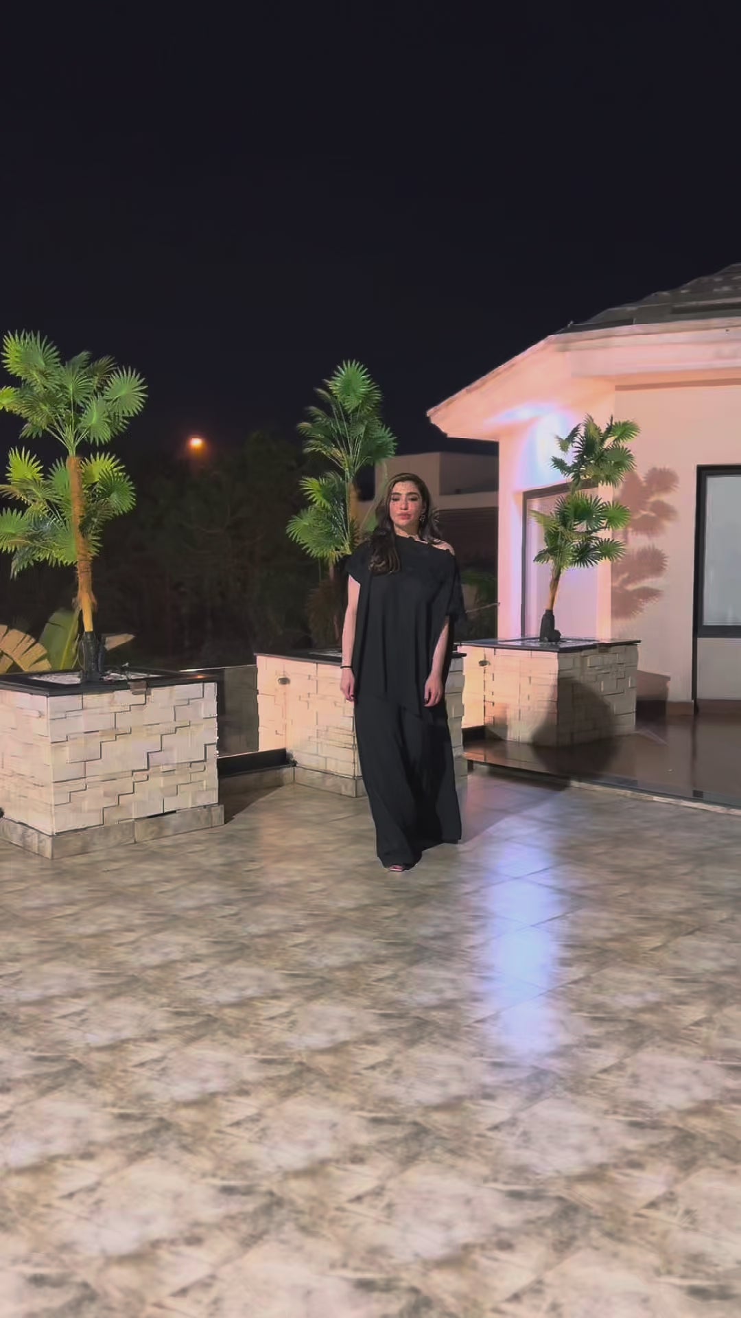 Video of black Velvet Smoke two-piece outfit featuring an off-shoulder top with lace cutwork and wide-leg box pants, styled for an elegant evening look.